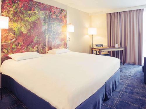 a large white bed in a hotel room at Mercure Lille Marcq en Baroeul in Marcq-en-Baroeul