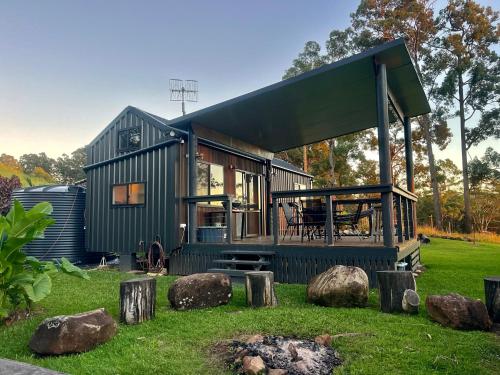 a green tiny house sitting on top of a yard at El Rancho Cabarita Beach - Highlander in Clothiers Creek