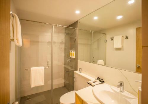 a bathroom with a shower and a sink and a mirror at Bloom Boutique Bangalore Palace Rd in Bangalore