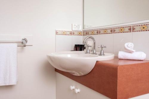 a bathroom with a white sink and a mirror at Moyne Views 2 in Port Fairy