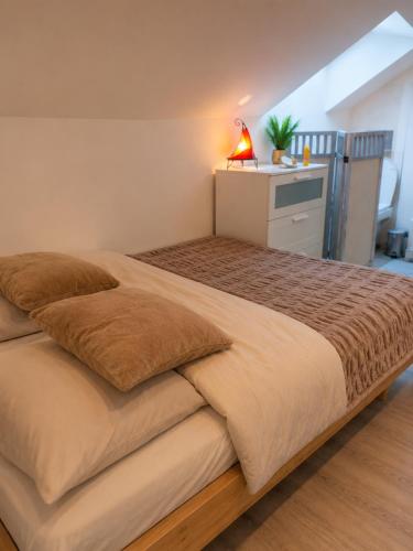 a bedroom with a large bed with a lamp on it at Duplex Le Doux Rêve in Dole