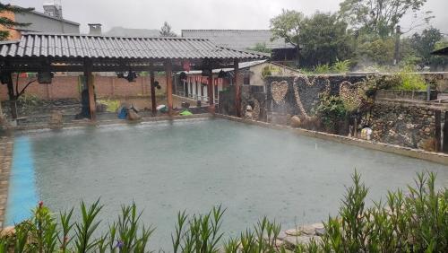 a large pool of water in front of a house at Nhà Gỗ Cạnh Suối in Bản Det