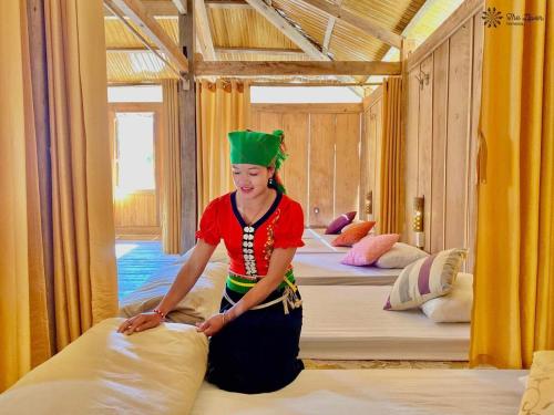 a woman in a room with a bunch of beds at Nhà Gỗ Cạnh Suối in Bản Det