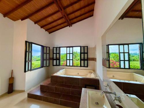 a large bathroom with a large tub and windows at Hotel Campestre Jardín Cafetero - Quindio in Armenia