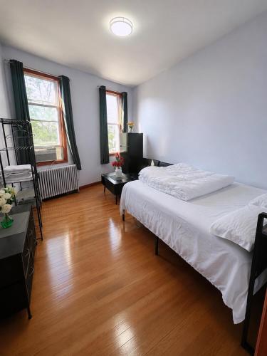 a bedroom with a white bed and a wooden floor at Amazing private Room in Glendale
