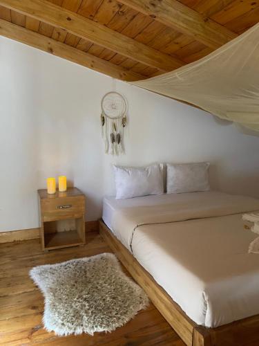 a bedroom with a bed and a night stand with a table at Tiny house with amazing view in Arusha