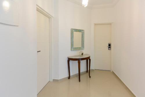 a white room with a table and a mirror at Louise village in Juquei