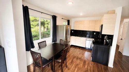 a kitchen with a table and chairs and a refrigerator at Mountain Views - Ocean Glimpses - Near Victoria - 2BR suite in Sooke