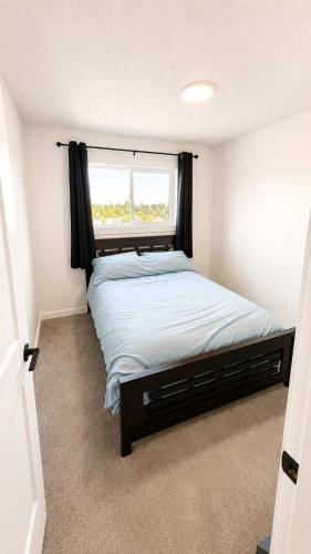 a bedroom with a large bed with a window at Mountain Views - Ocean Glimpses - Near Victoria - 2BR suite in Sooke