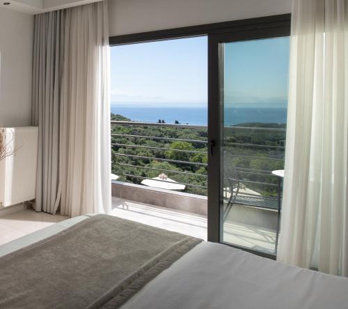 a bedroom with a bed and a view of the ocean at Suite Home in Anthoúsa