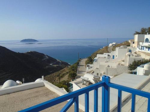 a view of the ocean from a balcony with white buildings at Panorama Rooms in Anafi