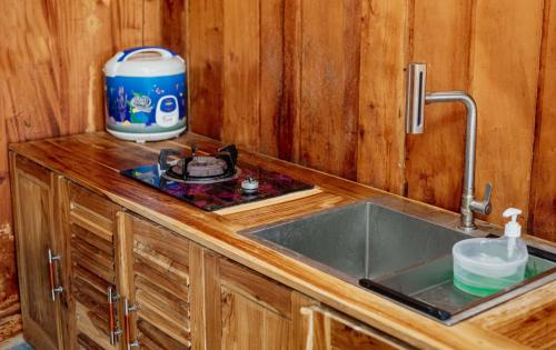 a kitchen counter with a sink and a mixer at Emerald Cabin House in Kejajar