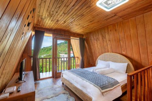 a bedroom with a bed and a large window at Emerald Cabin House in Kejajar