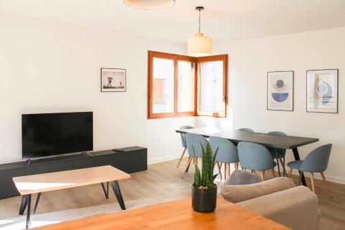 a living room with a tv and a table and chairs at Large apartment with balcony - Stade de France in Saint-Denis