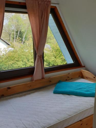 a bed in a room with a large window at Ferienhaus mit Pool am See in Malchow