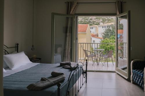 a bedroom with a bed and a balcony with a view at Karamelaki in Pythagoreio