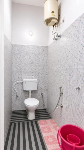 a bathroom with a toilet and a red tub at Eden Cozy Villa in Virāmpattinam