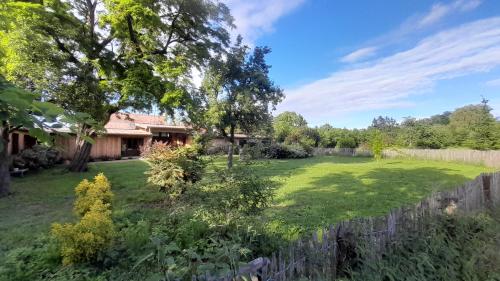 a yard with a fence and a house at Les Cottages du Chateau de Werde in Matzenheim