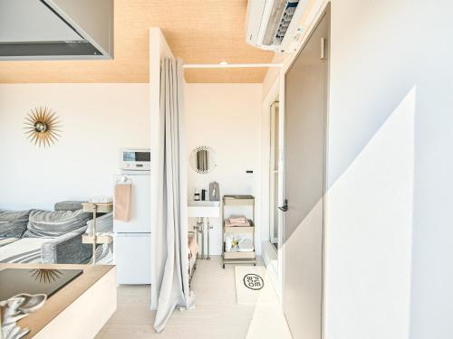 a small apartment with a hallway with a bed and a kitchen at Awaji Dog Hill in Kusumoto