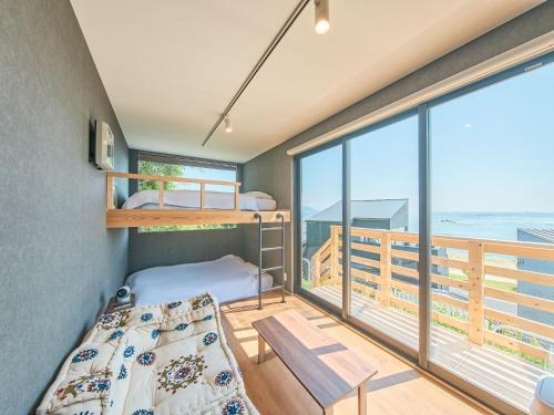 a bedroom with two bunk beds and a balcony at Awaji Dog Hill in Kusumoto