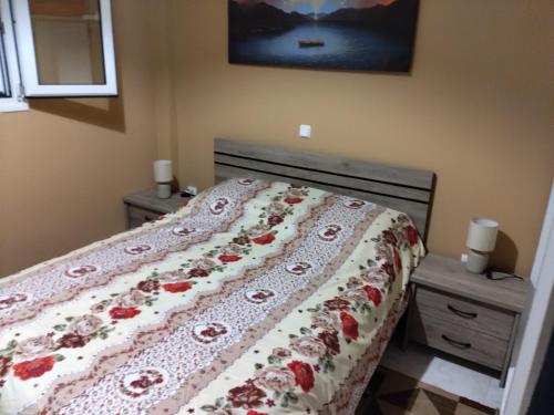 a bedroom with a bed with a floral comforter at Bee happy in Agioi Apostoli
