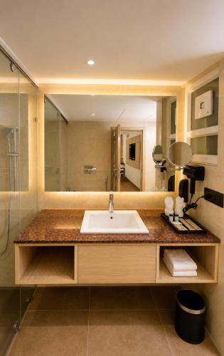 a bathroom with a sink and a large mirror at Pride Premier Greater Noida in Noida