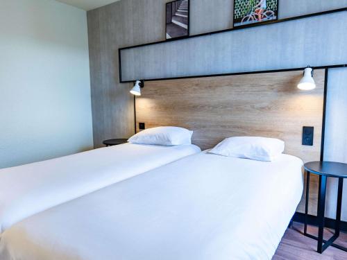 two beds sitting next to each other in a room at Ibis Agen Centre - Rénové en 2026 in Agen