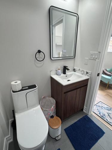 a bathroom with a toilet and a sink and a mirror at Home away from home! in Pickering