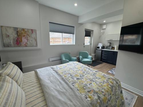 a bedroom with a bed and a kitchen at Home away from home! in Pickering
