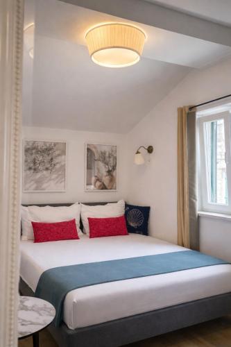 a bedroom with a large bed with red pillows at Stella Apartments in Kaštela