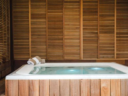 a jacuzzi tub in a room with wooden walls at Mercure Cabourg Hôtel & Spa in Cabourg