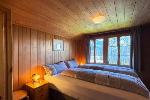a bedroom with a bed in a room with wooden walls at Chalet Bim Chilchli in Mürren