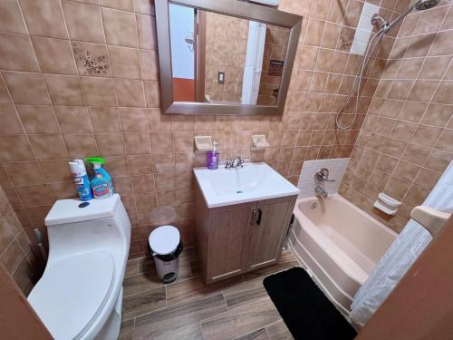 a bathroom with a toilet and a sink and a tub at Amazing private Room in Glendale