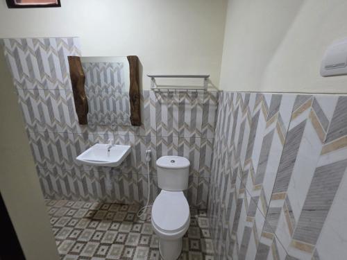 a bathroom with a toilet and a sink at Popeye Karimunjawa in Karimunjawa