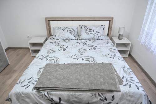 a bedroom with a bed with a blanket on it at Apartman biserna Sofija in Topola