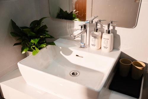 a white sink in a bathroom with a mirror at Lumia Hotel Vinh Yen in Vĩnh Phúc