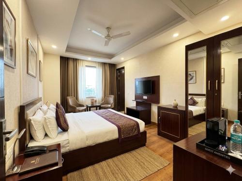 a hotel room with a bed and a television at Hotel Rajpath Residency 2 Min Walk From Kaushambhi Metro Station in Ghaziabad