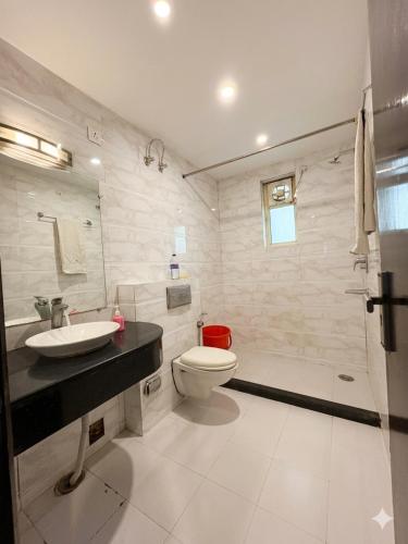 a bathroom with a toilet and a sink and a shower at Hotel Rajpath Residency 2 Min Walk From Kaushambhi Metro Station in Ghaziabad