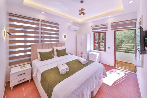 a bedroom with a large bed with towels on it at Kaşhan Otel in Kaş