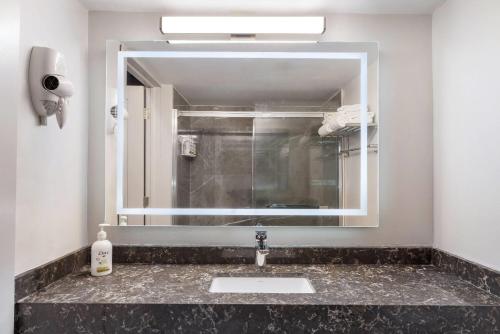 a bathroom with a sink and a mirror at Days Inn by Wyndham Sudbury & Conference Centre in Sudbury