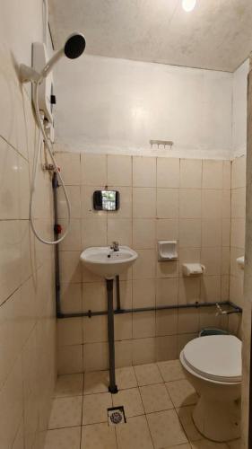 a bathroom with a sink and a toilet at AKI Backpackers in Ranau