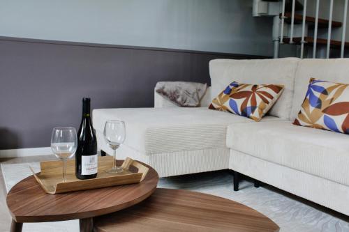 a living room with a white couch and a bottle of wine at Maison de charme in Bourgueil
