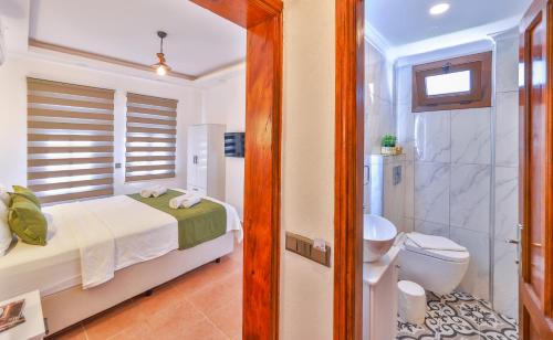 a bedroom with a bed and a shower and a toilet at Kaşhan Otel in Kaş