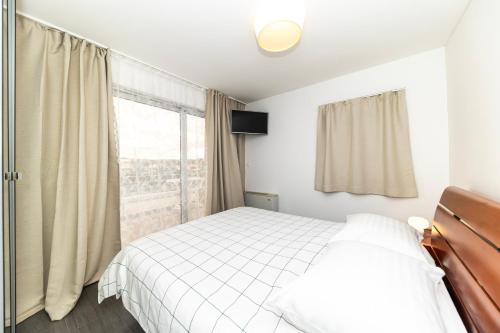 a bedroom with a white bed and a window at Villa Kovac in Zadar