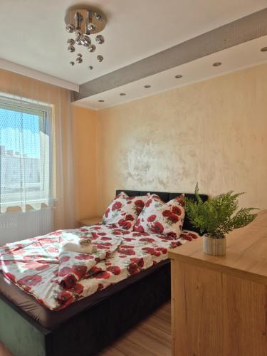 a bedroom with a bed with red flowers on it at Makowy Apartament in Milicz