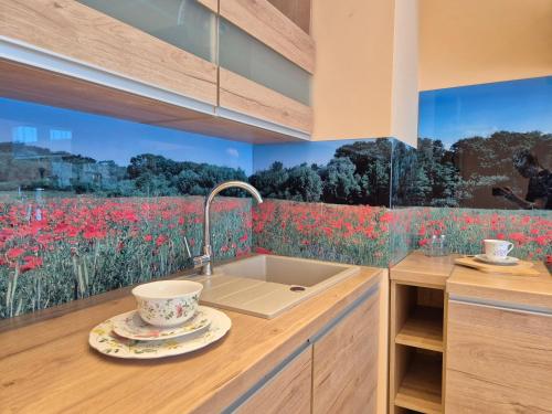 a kitchen with a sink and a field of red flowers at Makowy Apartament in Milicz