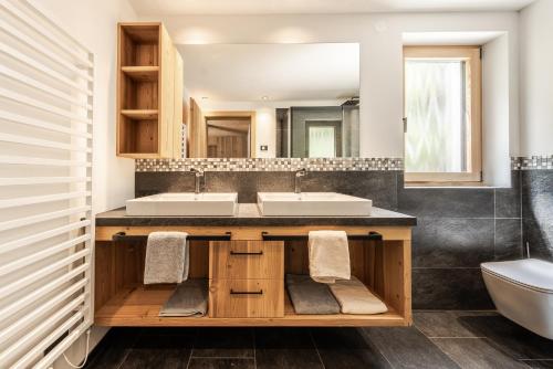 a bathroom with two sinks and a toilet at Chalet Esther in Longega