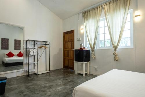 a bedroom with a bed and a tv in it at Coral Reef Holidays in Tioman Island