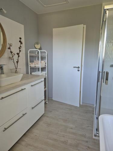 a bathroom with a sink and a white door at Justine's house in Alvignac in Alvignac