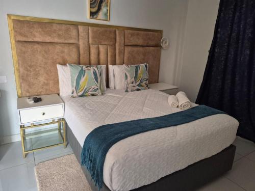 a bedroom with a large bed with a wooden headboard at Paradise Reho Guesthouse in Nata